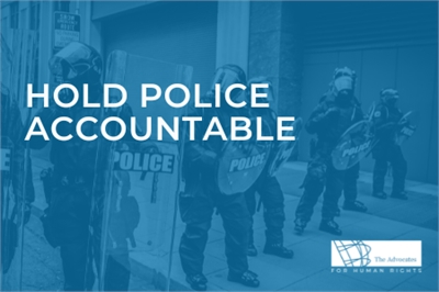 [ai] Police officers in riot gear standing in a line, holding shields and facing forward on a city street. Text overlay reads 'HOLD POLICE ACCOUNTABLE'. A logo for 'The Advocates for Human Rights' is visible in the bottom right corner.